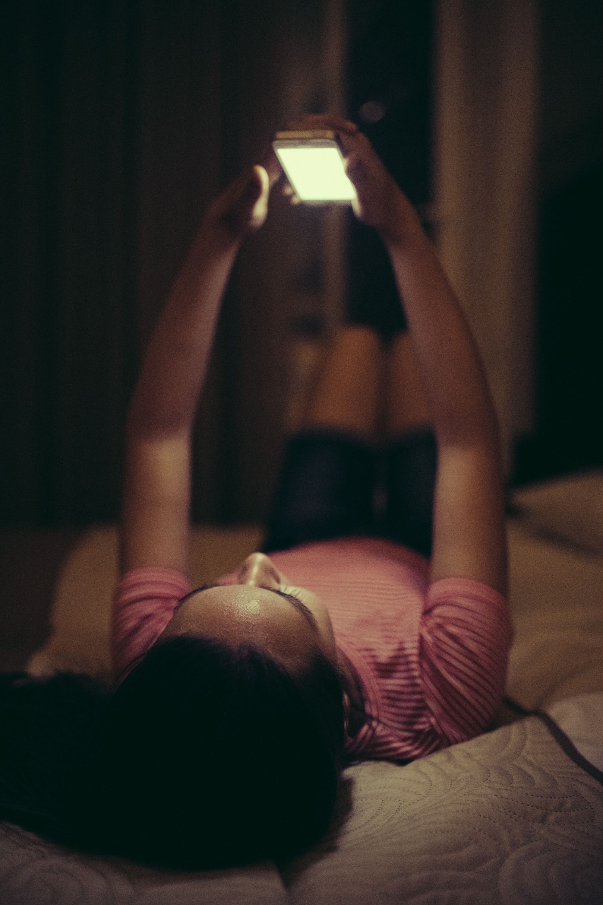 Woman with phone in bed