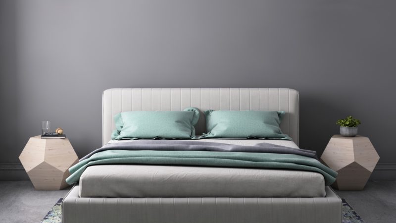 grey and teal mattress on clean creme linen bed frame with geometric night stands and lamps