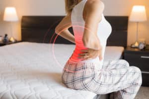 woman with back pain on a mattress