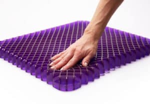 Hand pressing on Purple mattress material showing its softness and support
