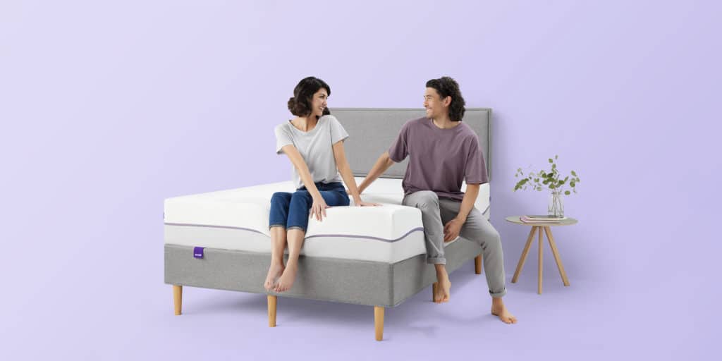 Couple sitting on a Purple Mattresses bed