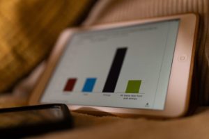 tablet with chart in darkly lit room on bed