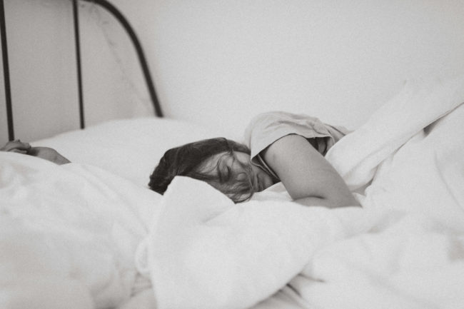 black and white image of a woman sleeping on her side