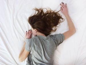 Woman sleeping on a mattress and sheets
