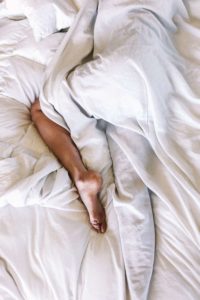 image of a person from the waist down side sleeping in a sheet